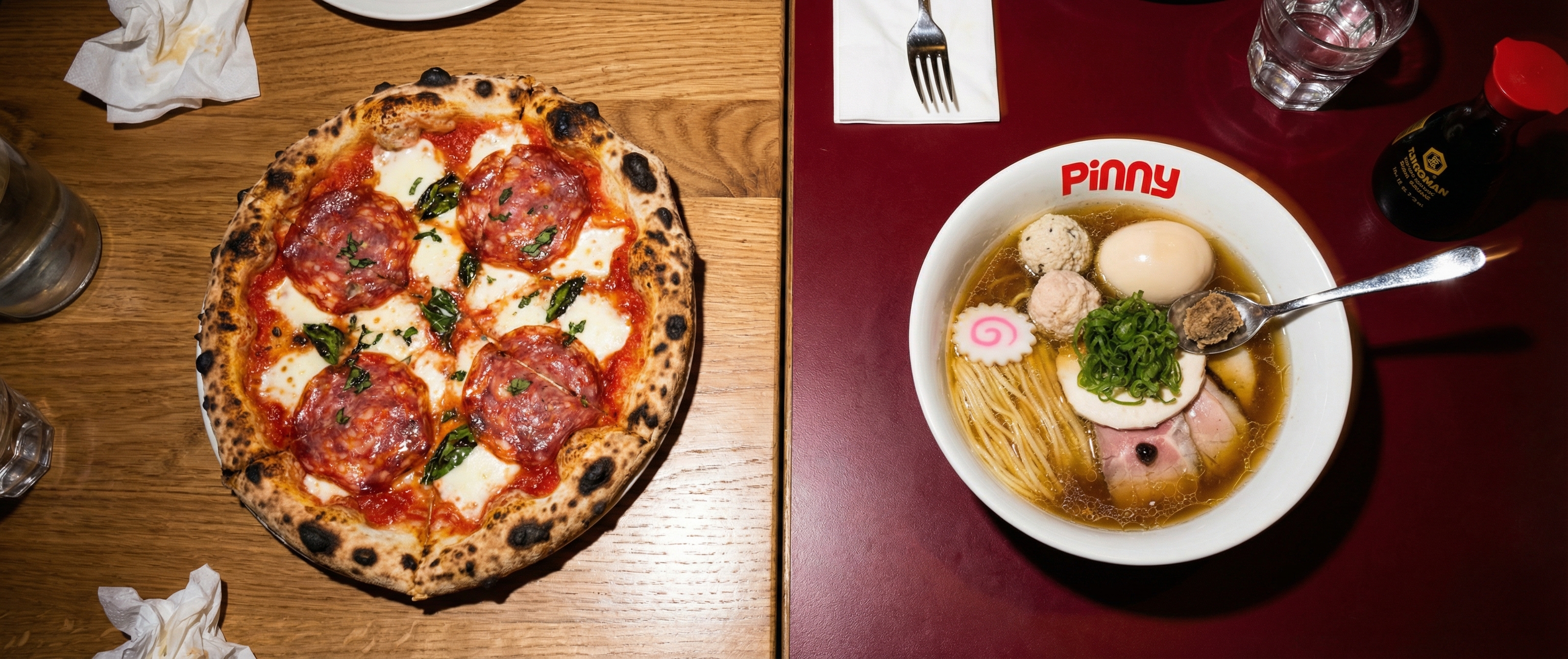 Pizza entière et bol de ramen sur une table simple